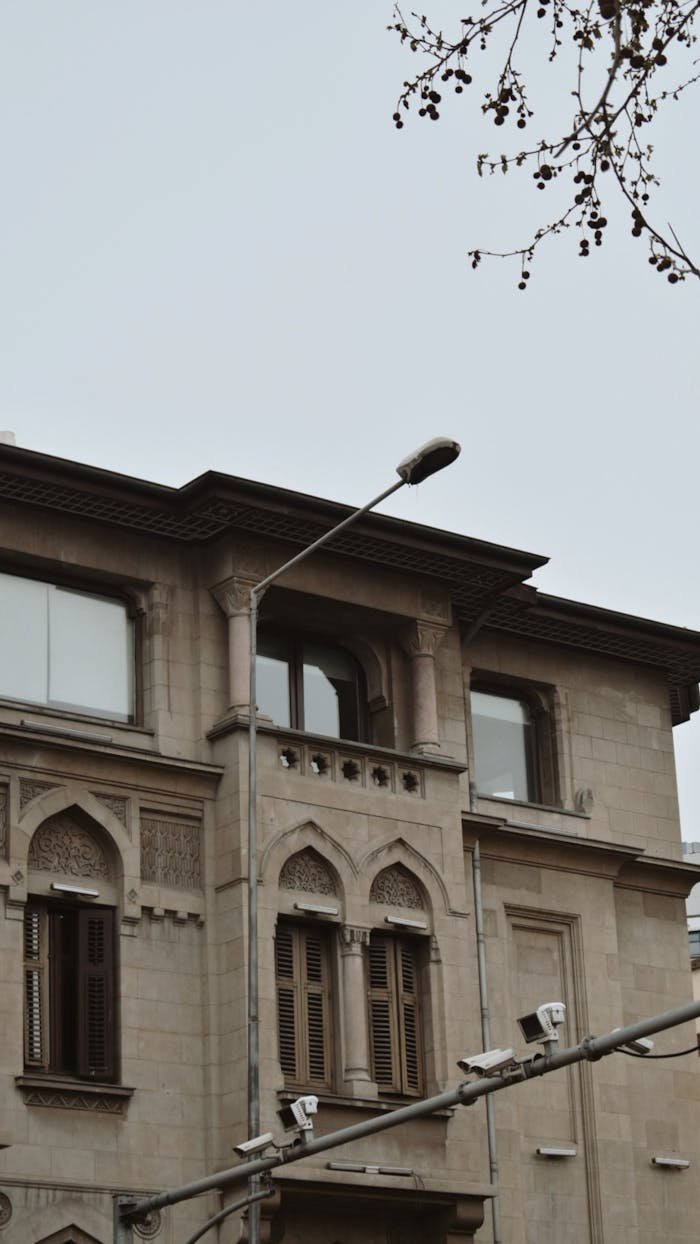 services-02 Historic stone building with ornate windows and streetlight in a city setting.