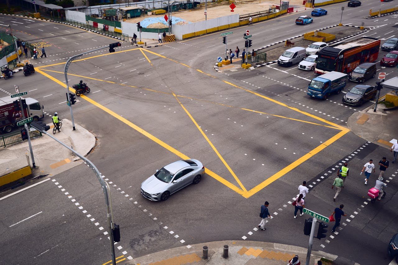 hero-img-02 An aerial view of a bustling urban intersection with vehicles and people crossing.